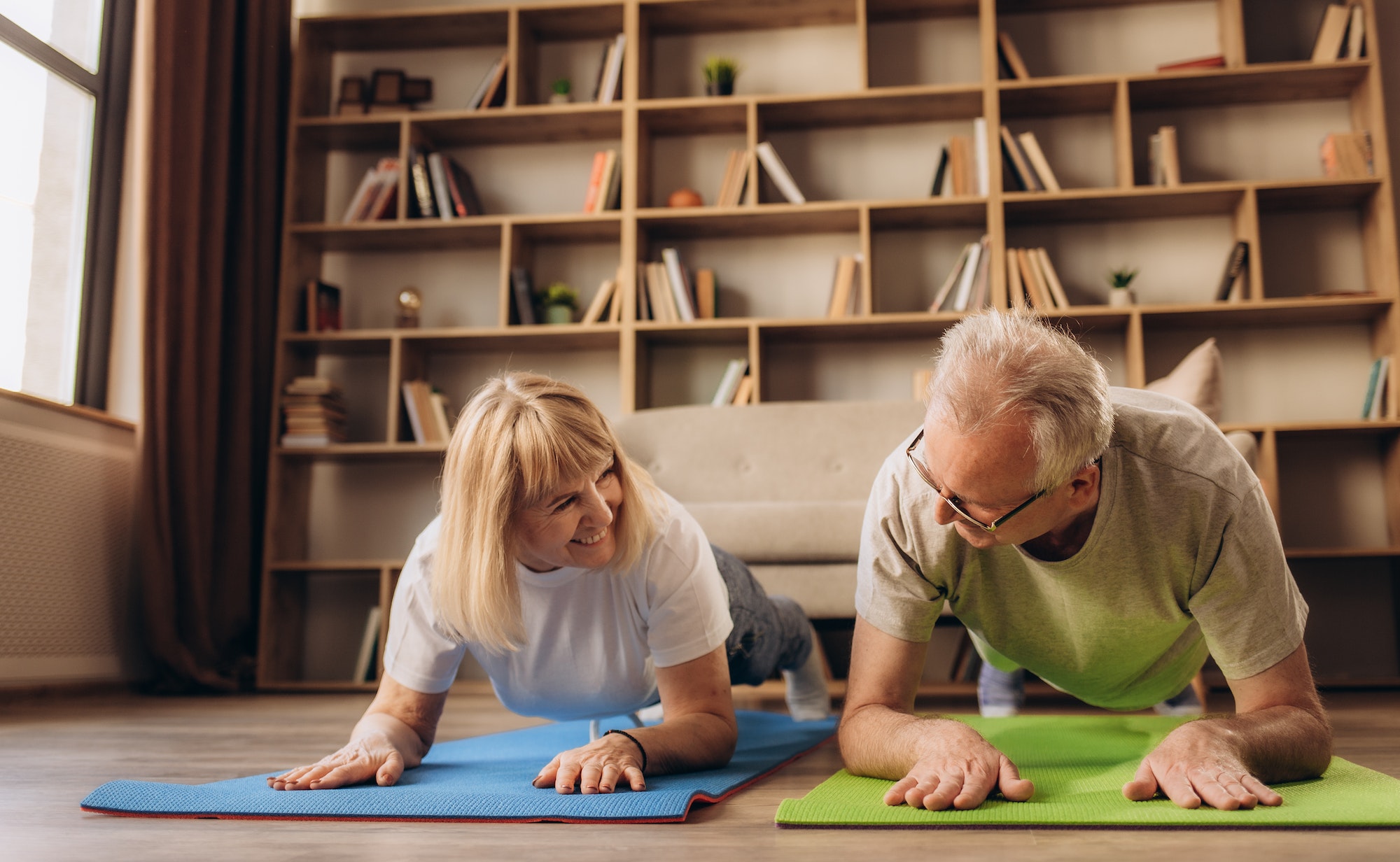 Portrait of a Senior Couple Doing Gymnastics and Yoga Stretching Exercises Together at Home on Sunny