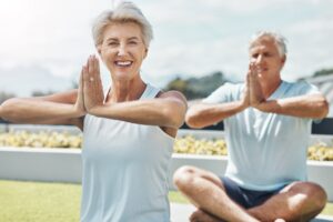 Senior couple, yoga and smile in meditation by the countryside for healthy spiritual wellness in na